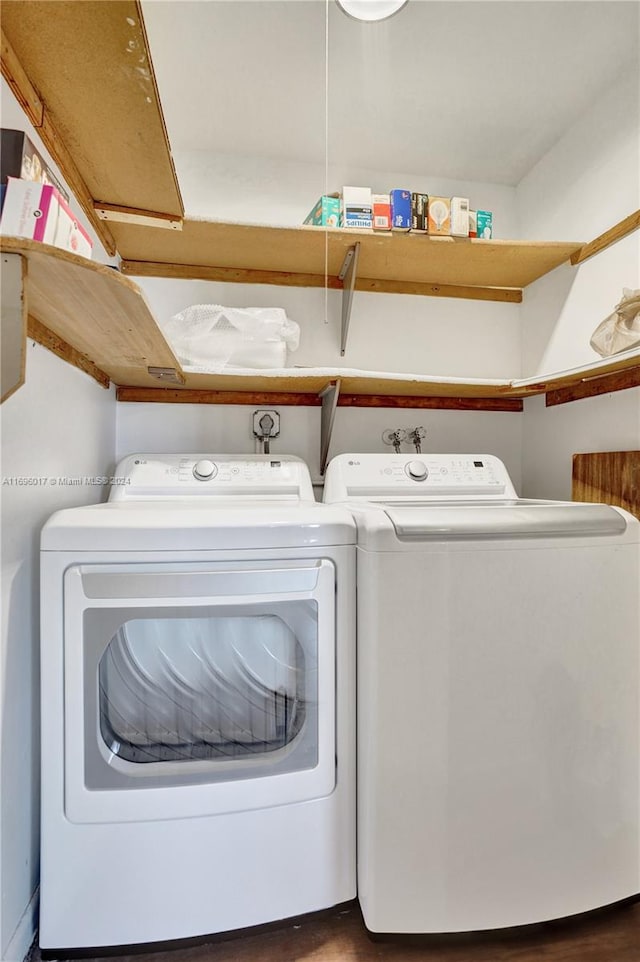 clothes washing area featuring washer and dryer and dark wood-type flooring