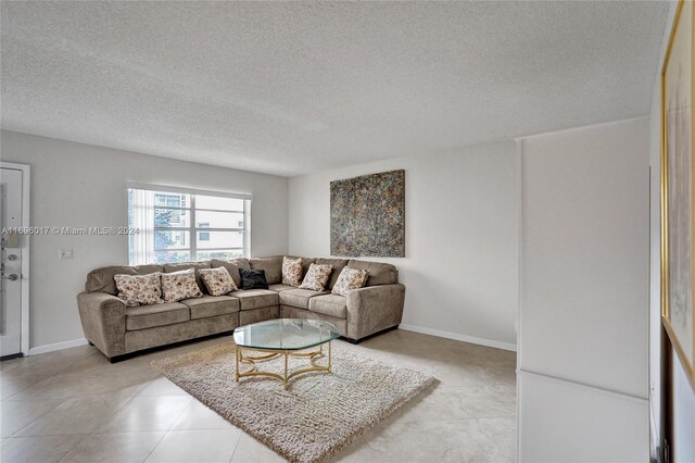 tiled living room featuring a textured ceiling