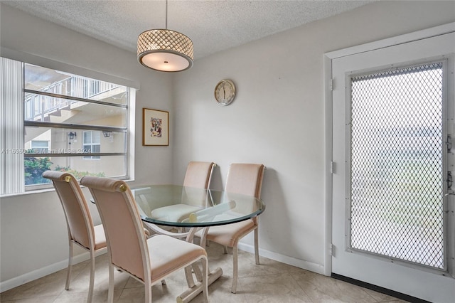 tiled dining area featuring a textured ceiling