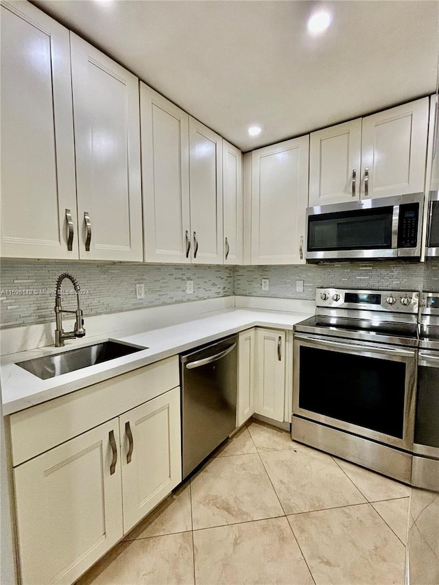 kitchen featuring sink, light tile patterned floors, stainless steel appliances, and tasteful backsplash