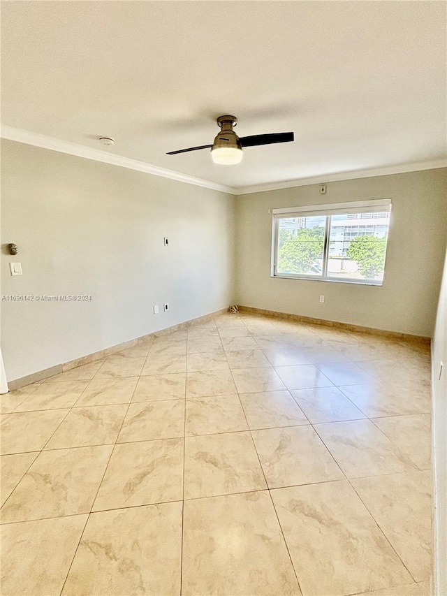 tiled empty room with ceiling fan and crown molding