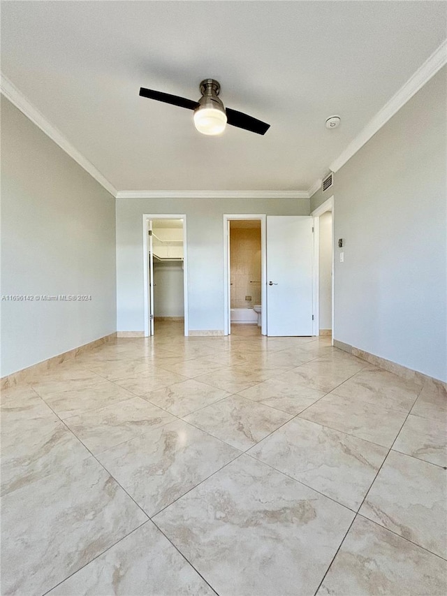 empty room featuring ceiling fan and crown molding