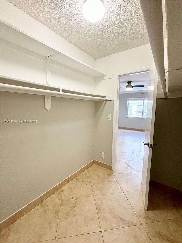 walk in closet featuring light tile patterned floors and ceiling fan