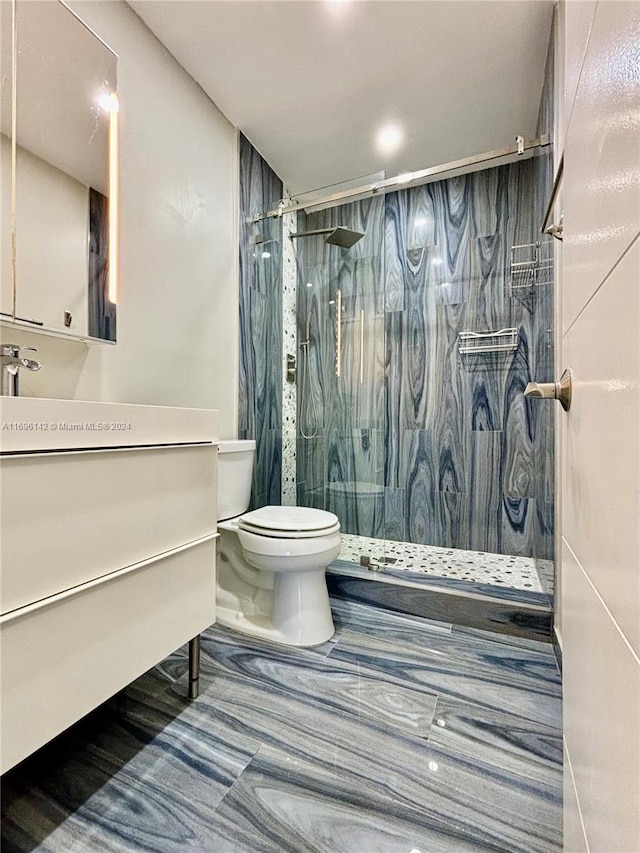 bathroom featuring vanity, toilet, and tiled shower