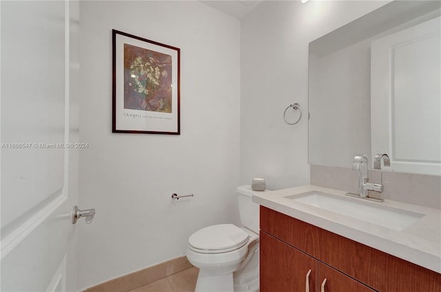 bathroom with tile patterned flooring, vanity, and toilet