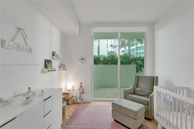 bedroom featuring light hardwood / wood-style flooring and a nursery area