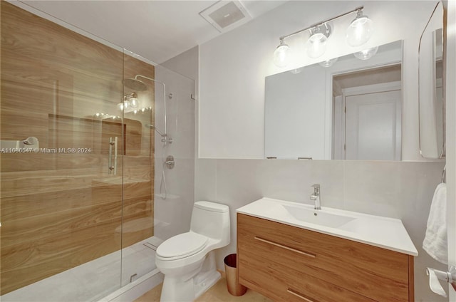 bathroom with vanity, backsplash, toilet, walk in shower, and tile walls