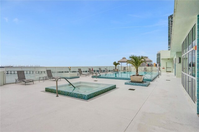 view of swimming pool with a patio and a hot tub