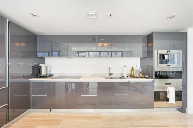 kitchen featuring gray cabinetry, sink, and black electric cooktop