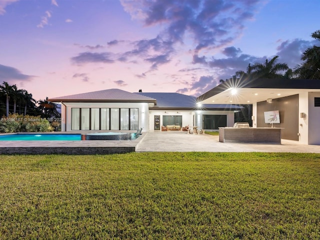 back house at dusk with an outdoor hangout area, a patio, and a yard