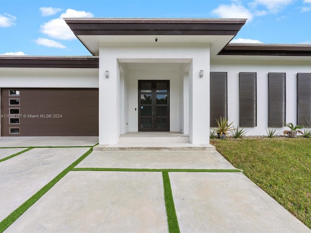 view of exterior entry with french doors and a garage