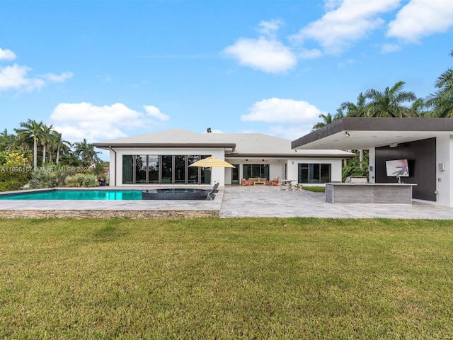 rear view of house with a lawn, an outdoor bar, and a patio