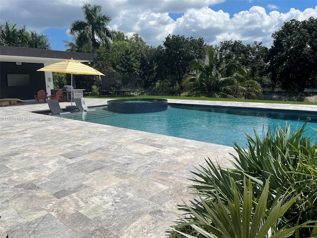 view of pool featuring a patio area and an in ground hot tub