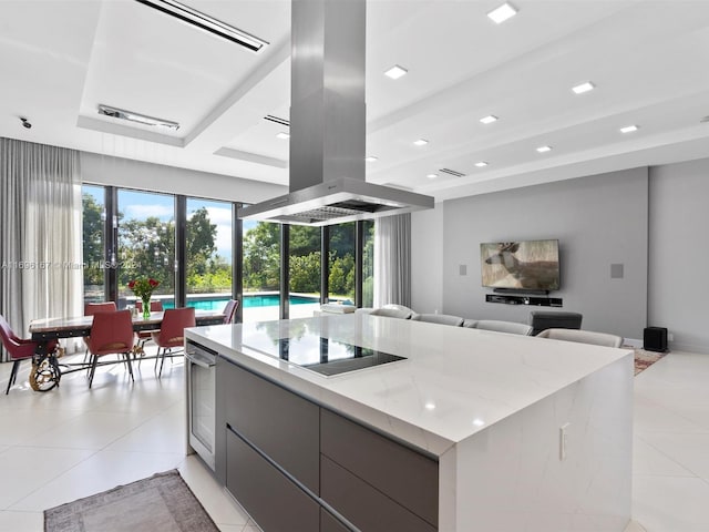 kitchen with island exhaust hood, black electric cooktop, a spacious island, wine cooler, and light tile patterned flooring