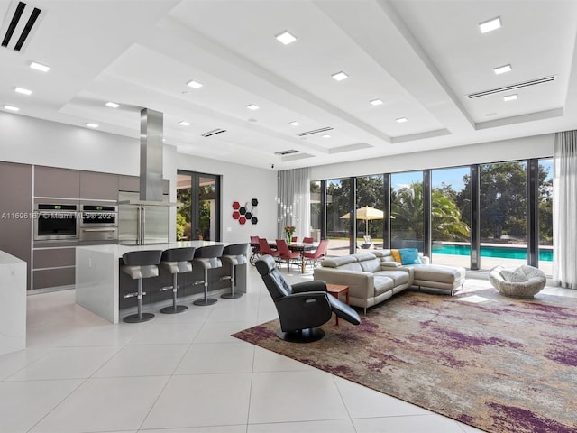 living room featuring beamed ceiling and light tile patterned flooring