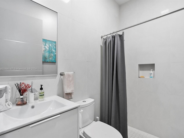 bathroom featuring toilet, vanity, tile walls, and walk in shower