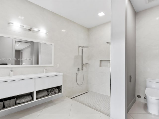 bathroom featuring tile patterned floors, vanity, toilet, and tile walls