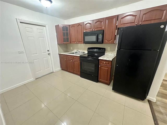 kitchen featuring sink, light tile patterned floors, and black appliances