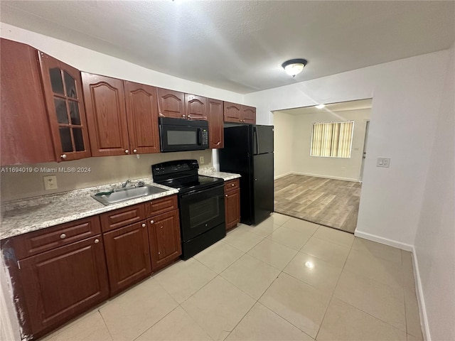 kitchen with sink, light hardwood / wood-style flooring, and black appliances