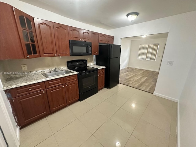 kitchen featuring sink, black appliances, and light wood-type flooring