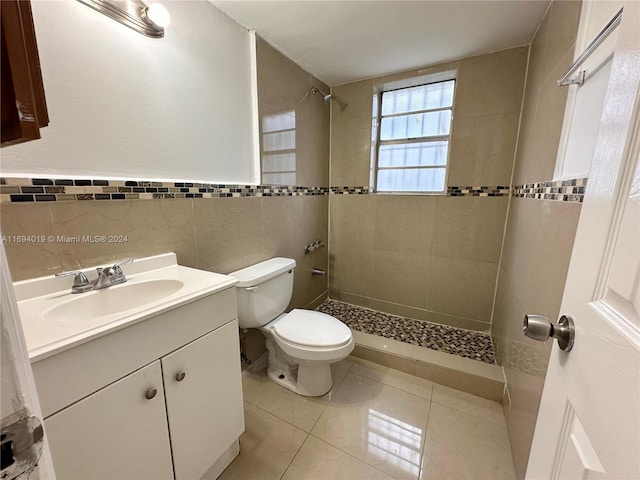 bathroom featuring tile patterned flooring, vanity, tile walls, and toilet