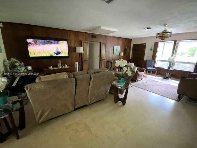 living room featuring wood walls and a chandelier