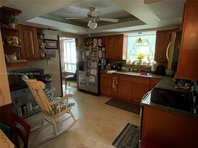 kitchen featuring a raised ceiling, a healthy amount of sunlight, and stainless steel appliances