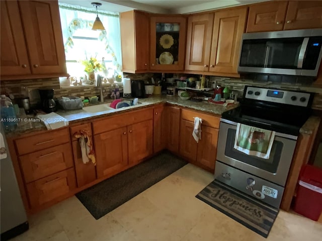 kitchen featuring decorative backsplash, hanging light fixtures, sink, and appliances with stainless steel finishes