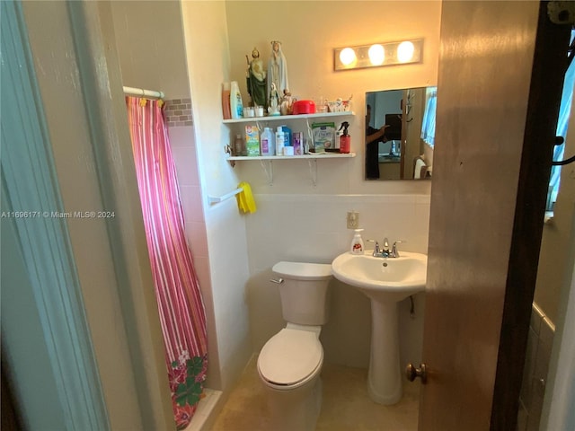 bathroom featuring toilet, tile walls, and curtained shower