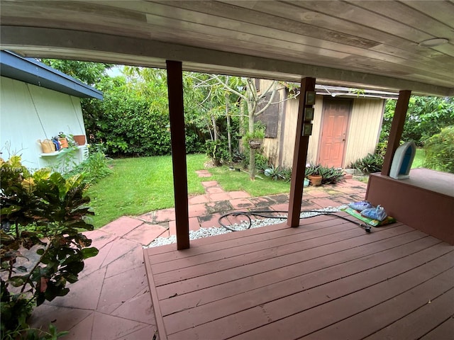 deck featuring a patio area, a yard, and a storage shed