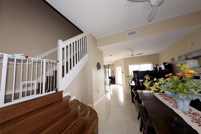 stairway featuring ceiling fan and tile patterned flooring