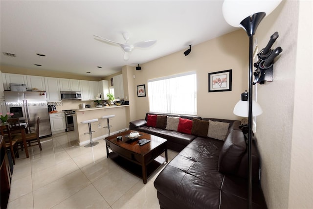 living room with ceiling fan and light tile patterned floors