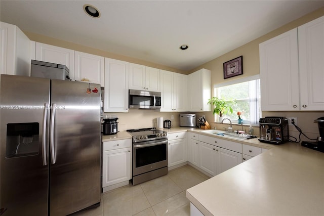 kitchen with white cabinets, light tile patterned floors, stainless steel appliances, and sink