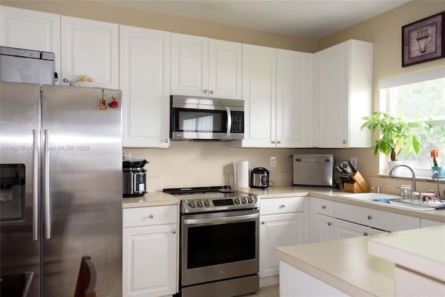 kitchen with white cabinets, stainless steel appliances, and sink