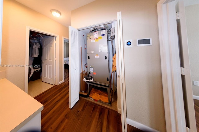 hallway with dark wood-type flooring and heating unit