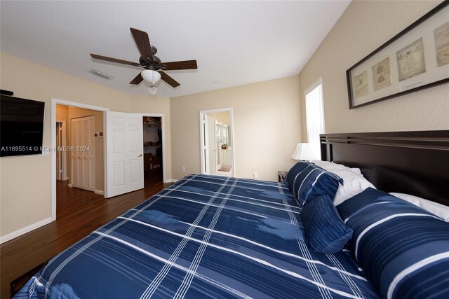 bedroom featuring ensuite bath, ceiling fan, a closet, and dark wood-type flooring