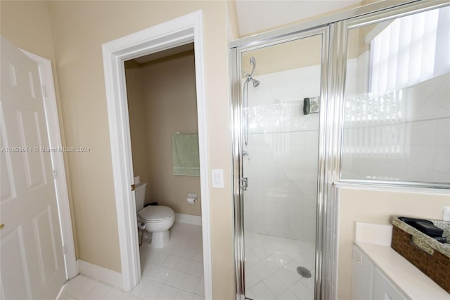 bathroom featuring tile patterned flooring, toilet, and an enclosed shower