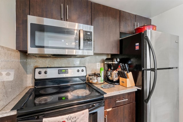 kitchen featuring dark brown cabinets, stainless steel appliances, and tasteful backsplash