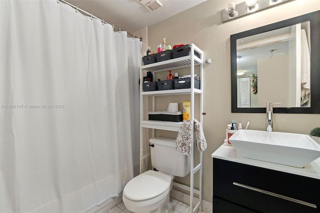 bathroom featuring tile patterned flooring, vanity, toilet, and walk in shower