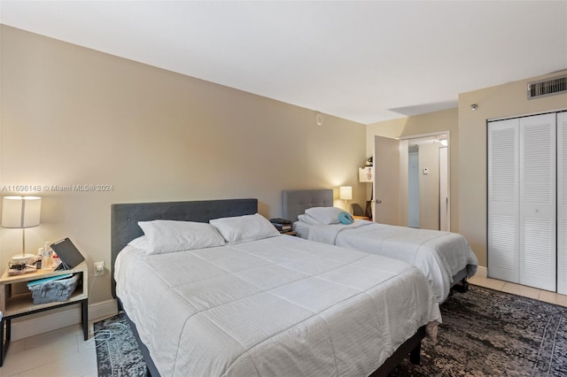 bedroom with tile patterned floors and a closet