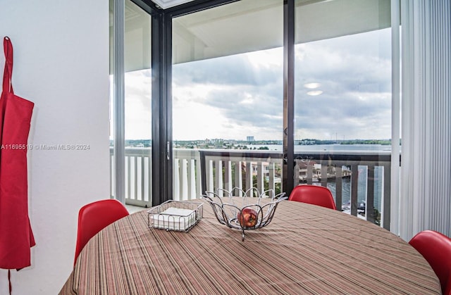 dining room featuring expansive windows, plenty of natural light, and a water view