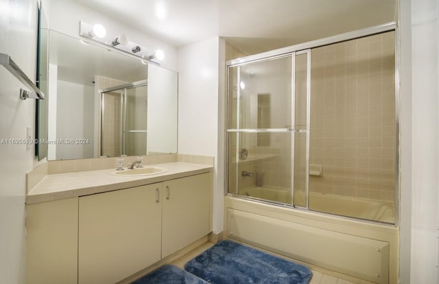 bathroom with combined bath / shower with glass door and vanity