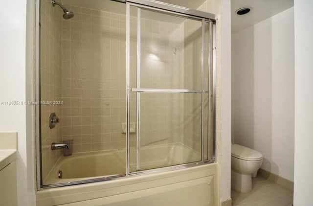 full bathroom featuring tile patterned floors, vanity, toilet, and bath / shower combo with glass door