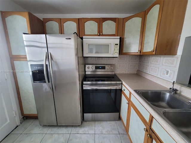 kitchen with decorative backsplash, sink, and stainless steel appliances