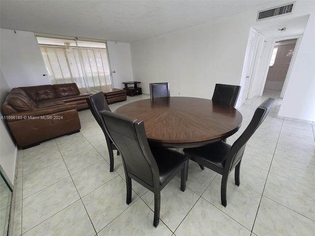 tiled dining area with a textured ceiling