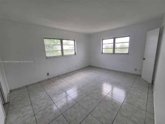 tiled spare room featuring a wealth of natural light