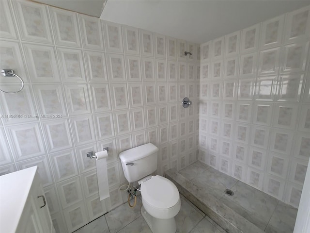 bathroom featuring a shower, tile patterned floors, tile walls, and toilet