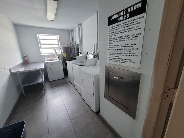 laundry area with washer and dryer and dark tile patterned flooring