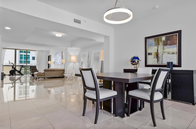 tiled dining room with a tray ceiling