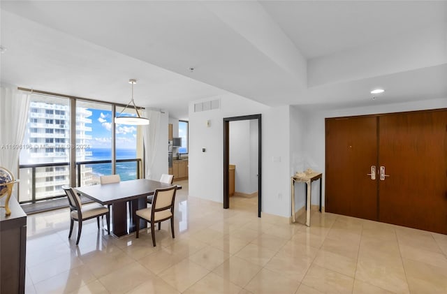 dining space featuring a water view and light tile patterned floors